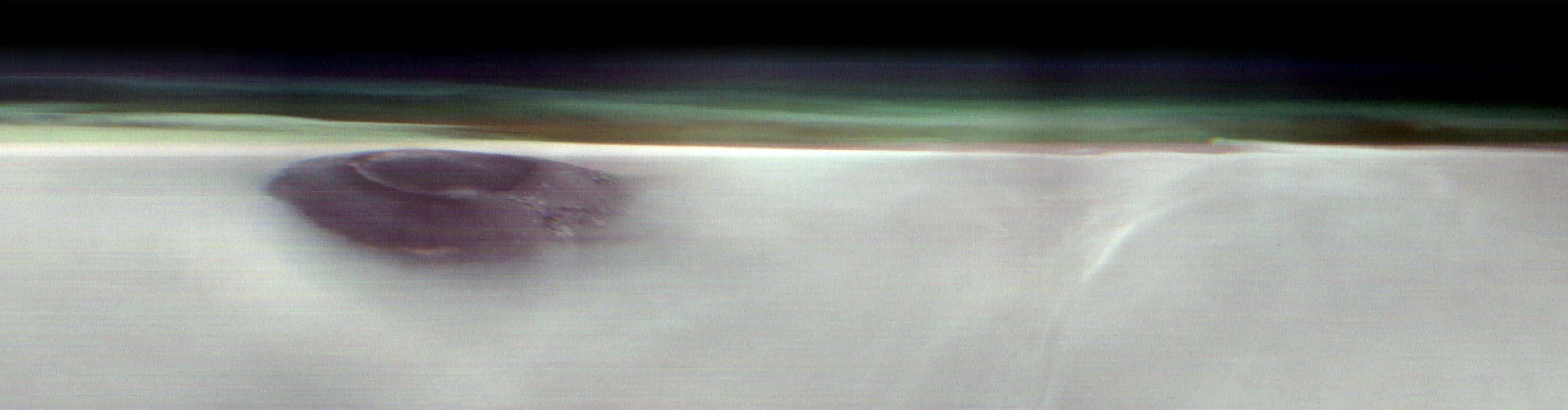 A black mountain peak shows through water ice clouds on Mars. Just above the clouds is the hazy green Martian atmosphere.